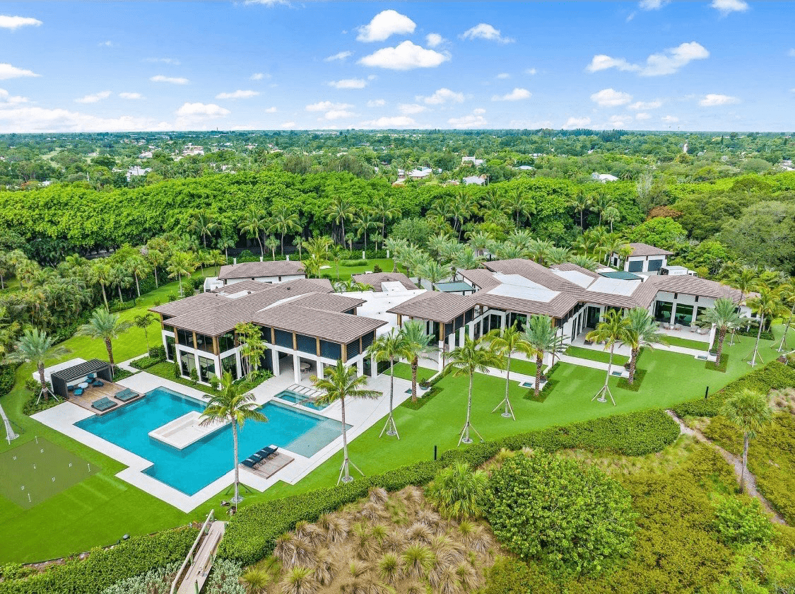 An aerial view of a sprawling luxury estate with a large pool